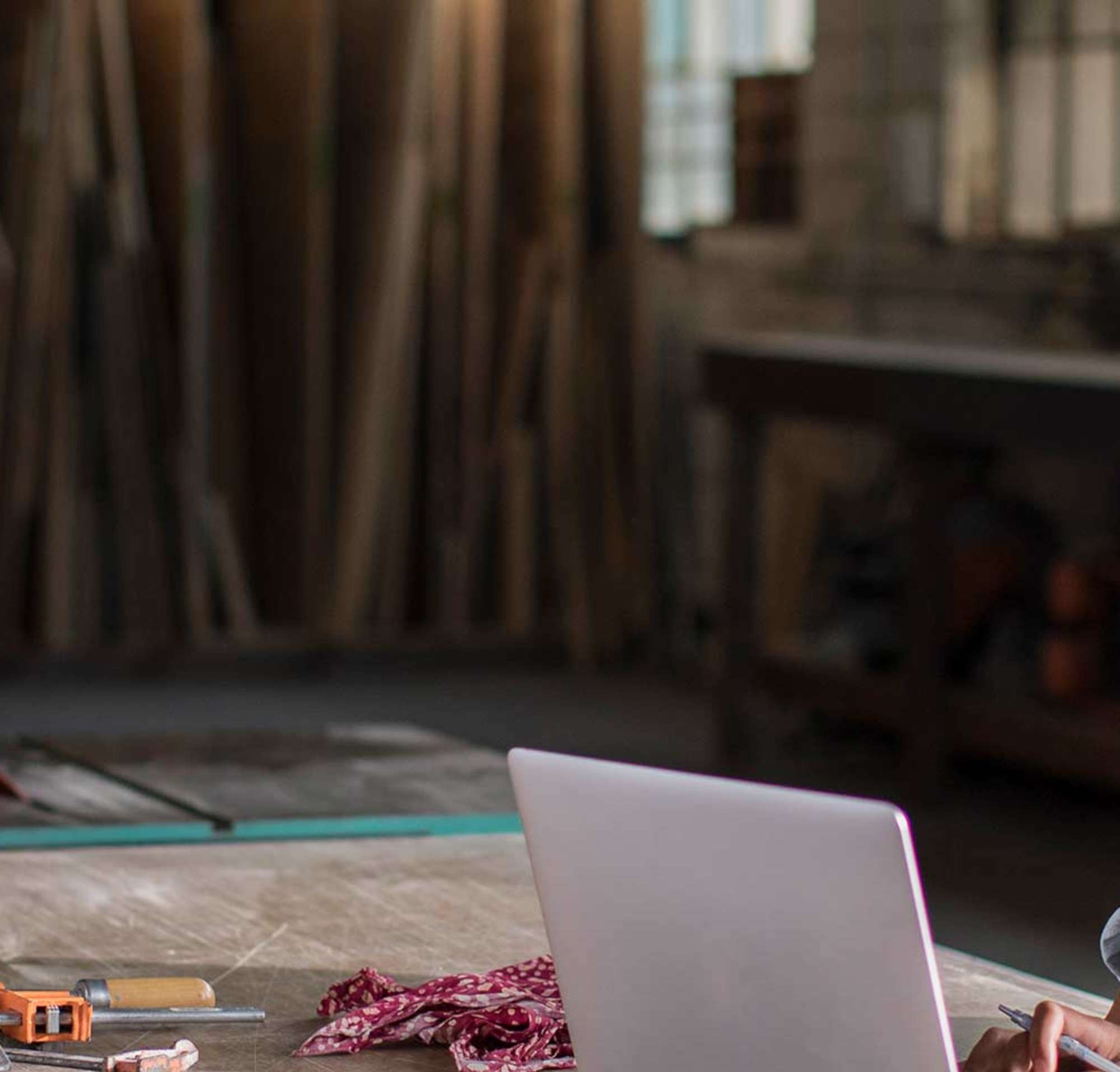 Young woman working from a laptop in her woodshop