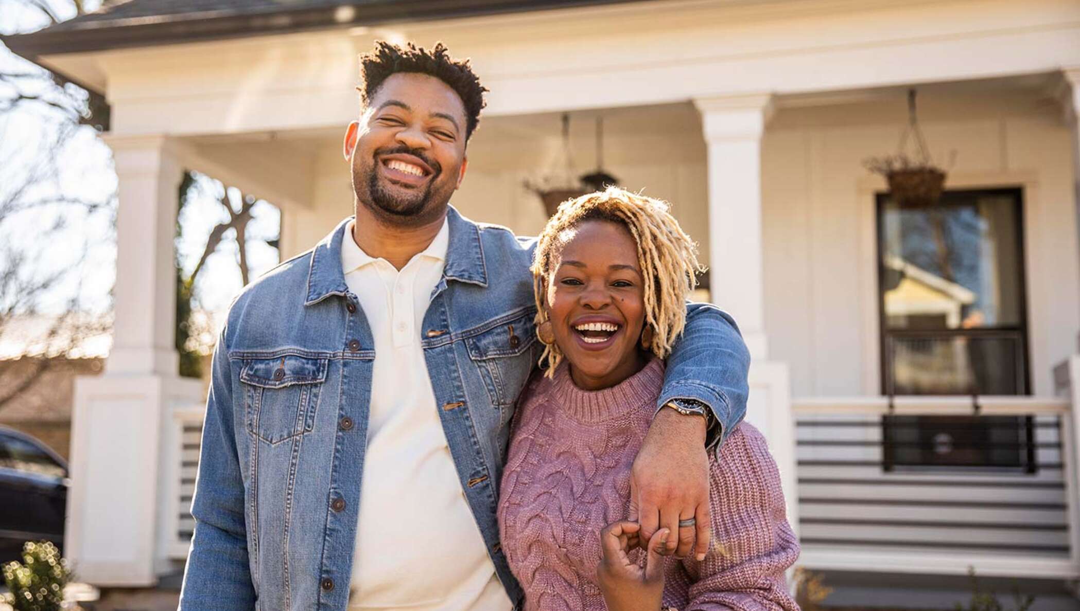 Image of two people outside their new home.