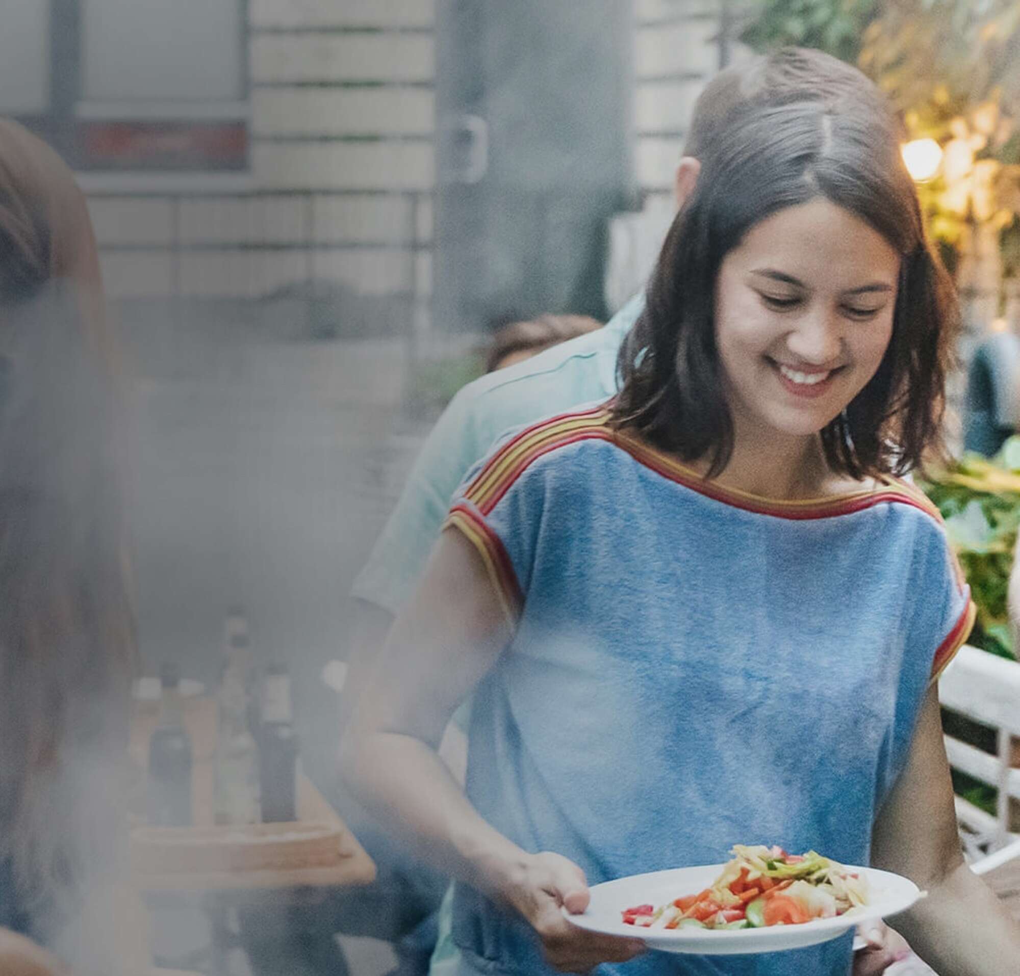 Image of two people getting food at a barbeque in their new home.