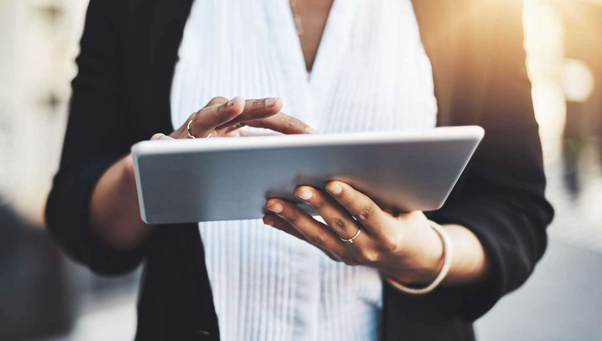 A businesswoman is checking her tablet for information on a document to sign