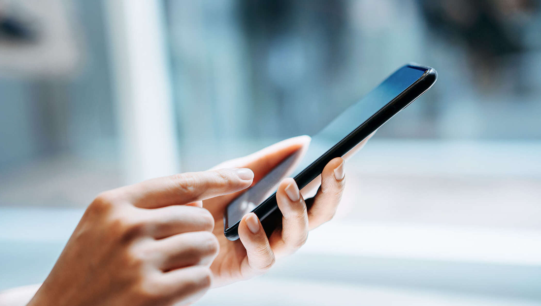 Woman’s hand holding up a smartphone for business.