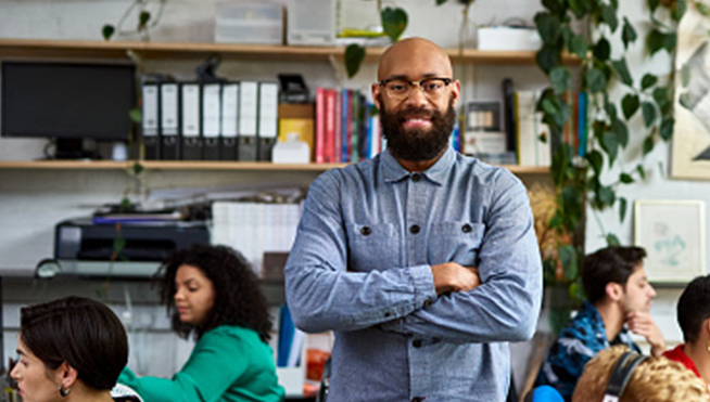 Man standing amid office workers.