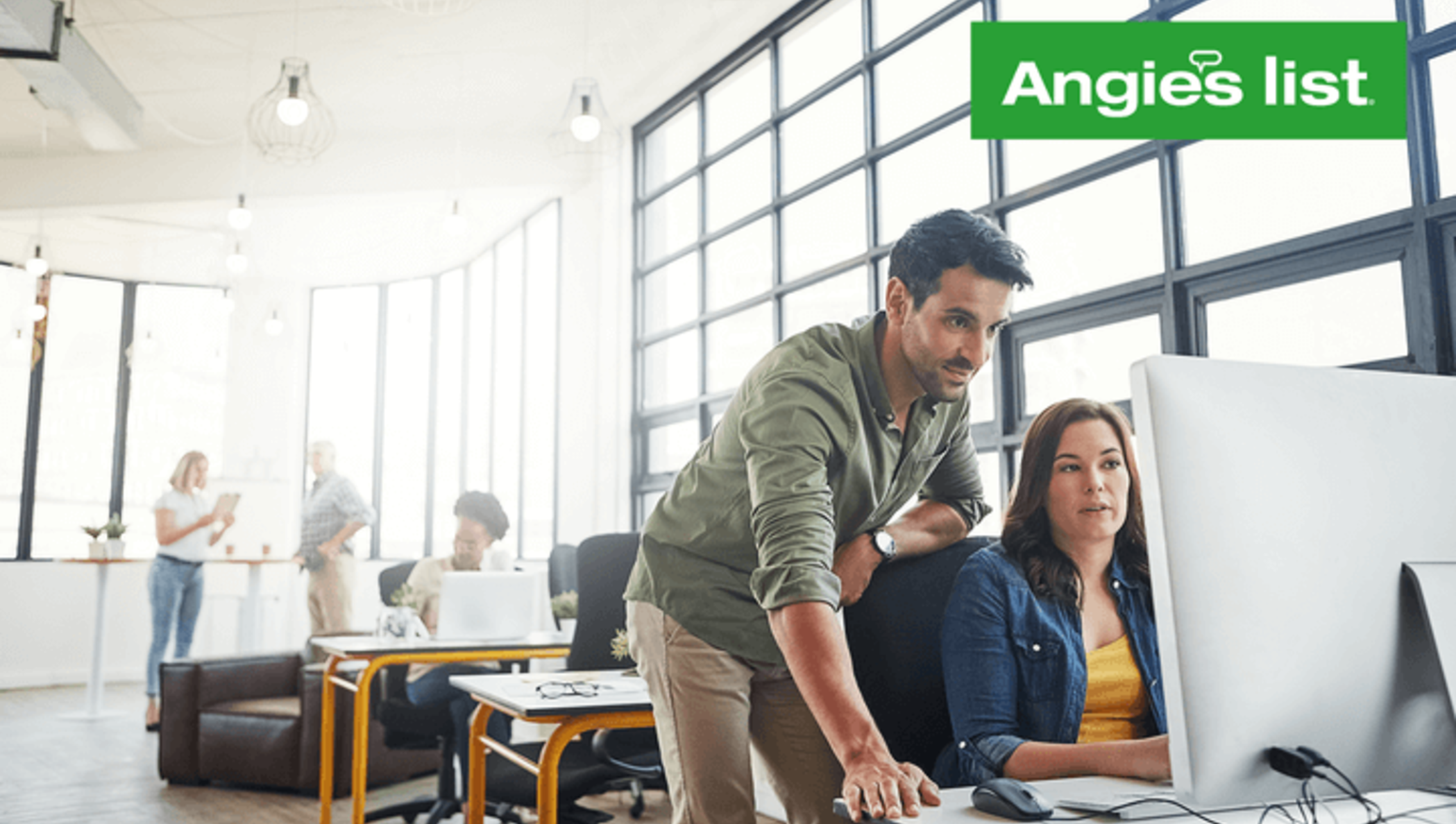 Several people working in a bright office, the Angie’s List logo in the top right corner.